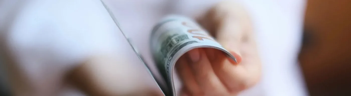 A person holding a dollar bill in their hands.