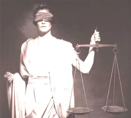 A woman holding a scale and blindfold in front of her face.