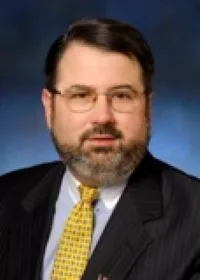 A man with a beard and glasses wearing a suit
