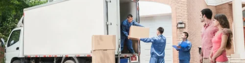Three men unloading boxes from a moving truck.