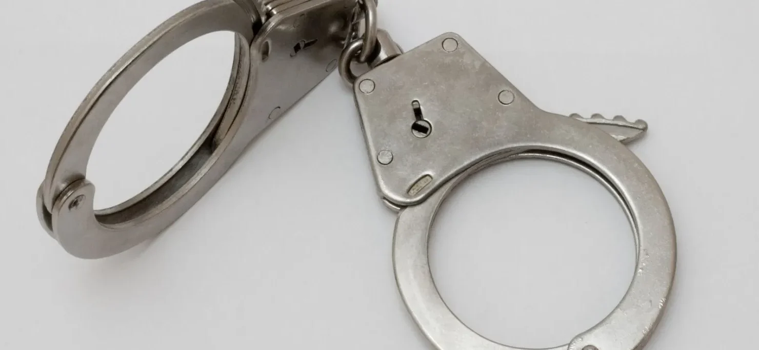 A pair of handcuffs on top of a white table.
