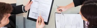 A group of people sitting around a table with papers.