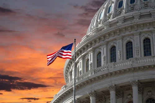 A flag flies in front of the capitol building.