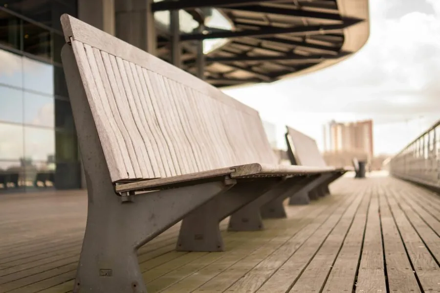 A row of benches on the side of a walkway.