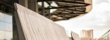 A row of benches on the side of a walkway.