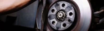 A person holding onto the brake disc of their car