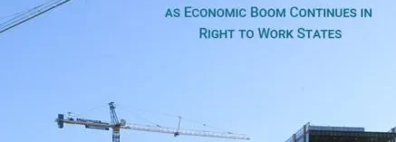 A crane is in the sky with buildings behind it.