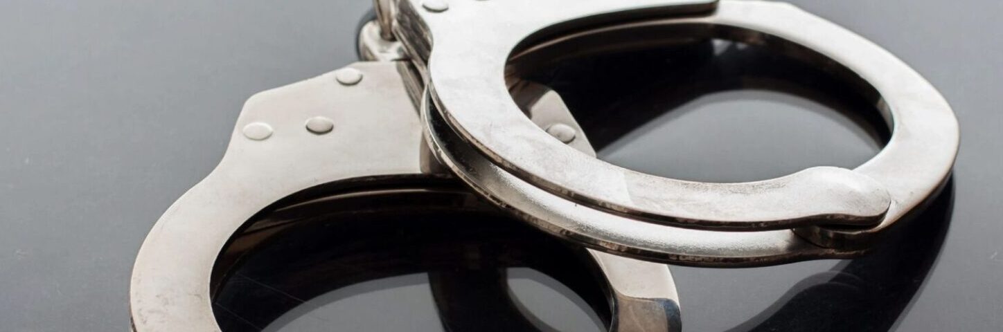 qtq80-5eFCzf A pair of handcuffs on top of a table.