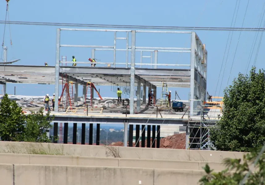 A building under construction with workers standing on top of it.