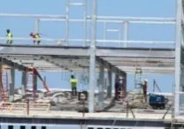 A building under construction with workers standing on top of it.