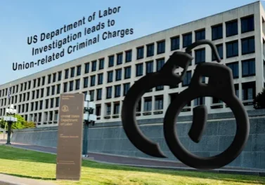 A large building with a sign and sculpture in front of it.