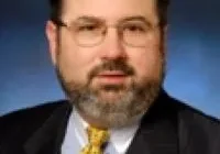 A man with a beard and glasses wearing a suit
