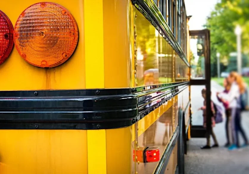 A yellow bus is parked on the side of the road.