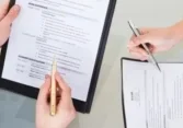 A group of people sitting around a table with papers.