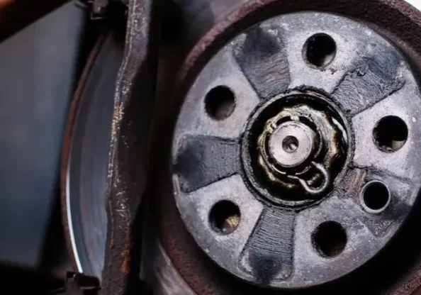 A person holding onto the brake disc of their car