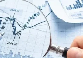 A person holding a magnifying glass over some graphs