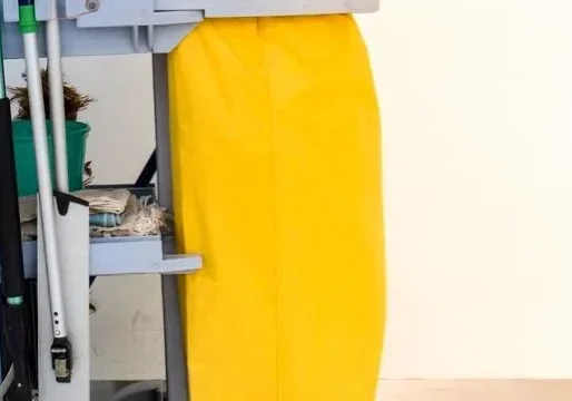 A yellow cleaning cart with buckets and poles.