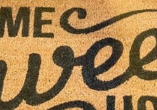 A woman is sitting on the floor next to her shoes.