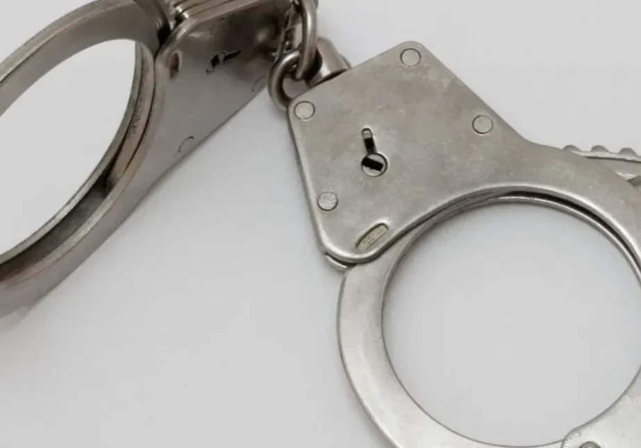 qtq80-ojg53Q (1) A pair of handcuffs on top of a white table.