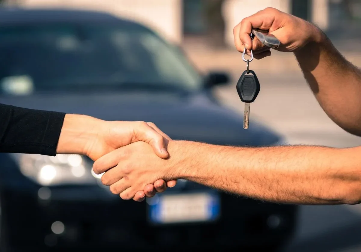 A man handing over the keys to another person.