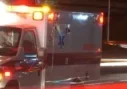A blurry ambulance driving down the street at night.